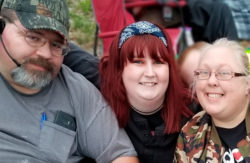 Rebecca Lahue leans in for a photo with her husband and daughter.