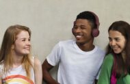 Three teens smiling and looking at each other
