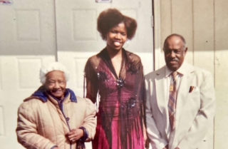 Jamerika and the Johnsons smiling outside of a building