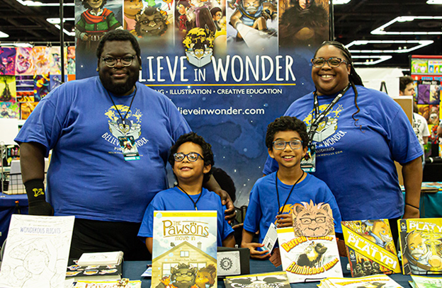 Brian and Josie Parker and their two children stand behind a display of books from their publishing company, Believe in Wonder. Book titles include _The Pawsons_ and _You Can Rely on Platypi_.