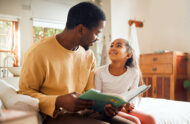 A father and daughter read a children's book together.