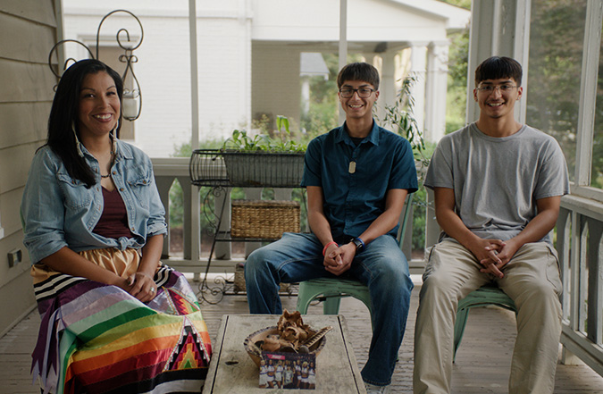 2026-05-Taylor-Kelin-Nick-photo A mother, Taylor, sits with her two sons, Kelin and Nick, while sitting and smiling together on a porch outside.